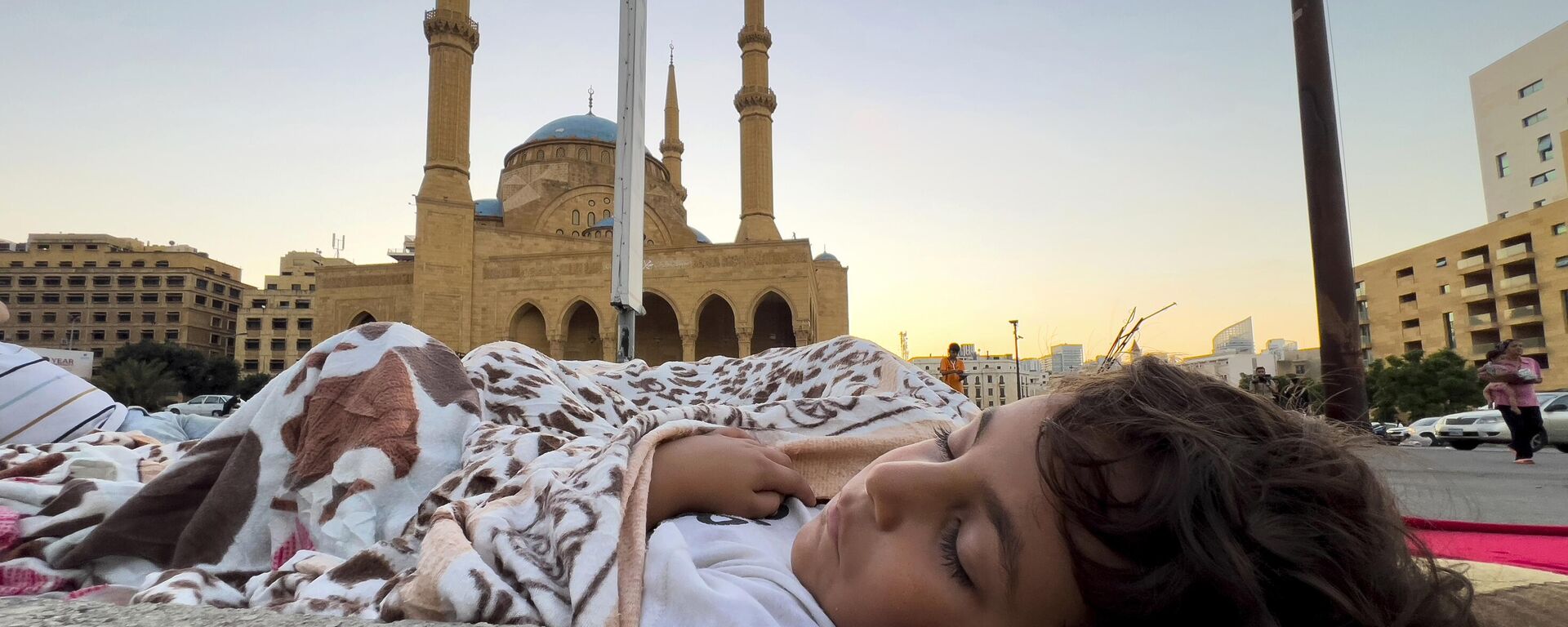 Cậu bé chạy trốn khỏi các cuộc không kích của Israel từ vùng ngoại ô phía nam Beirut cùng gia đình ngủ trên đường phố ở trung tâm Beirut - Sputnik Việt Nam, 1920, 16.10.2024