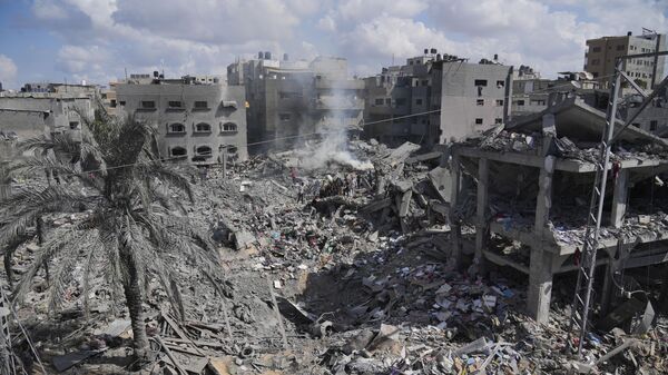 Palestinians search for the people killed in an Israeli airstrike in Bureij refugee camp Gaza Strip, Wednesday, Oct. 18, 2023 - Sputnik Việt Nam