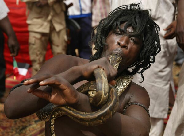 Người đàn ông nhét con rắn sống vào miệng khi phát biểu tại cuộc biểu tình ở hạt Mayo, Sudan - Sputnik Việt Nam