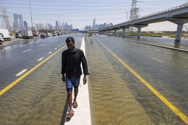 Người đàn ông đi dọc đường Sheikh Zayed trong thời gian lũ lụt ở Dubai, Các Tiểu vương quốc Ả Rập Thống nhất - Sputnik Việt Nam