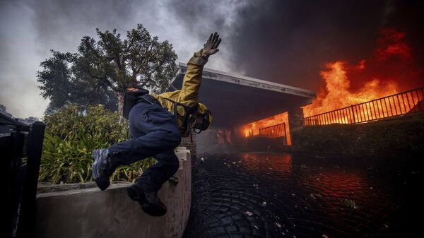 Một lính cứu hỏa nhảy qua hàng rào khi chữa cháy ở Los Angeles, Hoa Kỳ - Sputnik Việt Nam