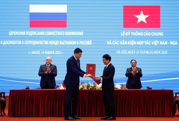 Ngày 14 tháng 1 năm 2025. Bộ trưởng Công Thương Liên bang Nga Anton Alikhanov và Bộ trưởng Thông tin và Truyền thông Việt Nam Nguyễn Mạnh Hùng trong lễ ký Biên bản ghi nhớ giữa Bộ Công Thương Liên bang Nga và Bộ Thông tin và Truyền thông Việt Nam trong lĩnh vực công nghiệp vô tuyến điện tử và công nghệ số. Phía sau: Thủ tướng Nga Mikhail Mishustin và Thủ tướng Việt Nam Phạm Minh Chính - Sputnik Việt Nam