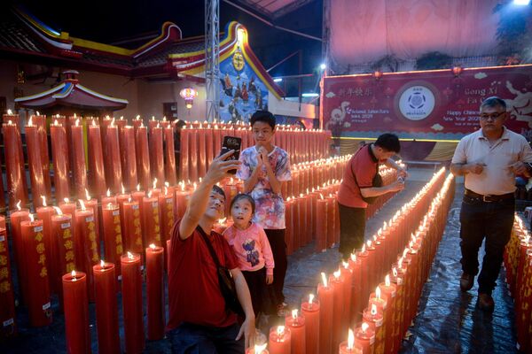 Một gia đình chụp ảnh với nền là nến tại đền Dhana Gun ở Bogor, Tây Java, Indonesia, để kỷ niệm Tết Nguyên Đán Trung Quốc - Sputnik Việt Nam