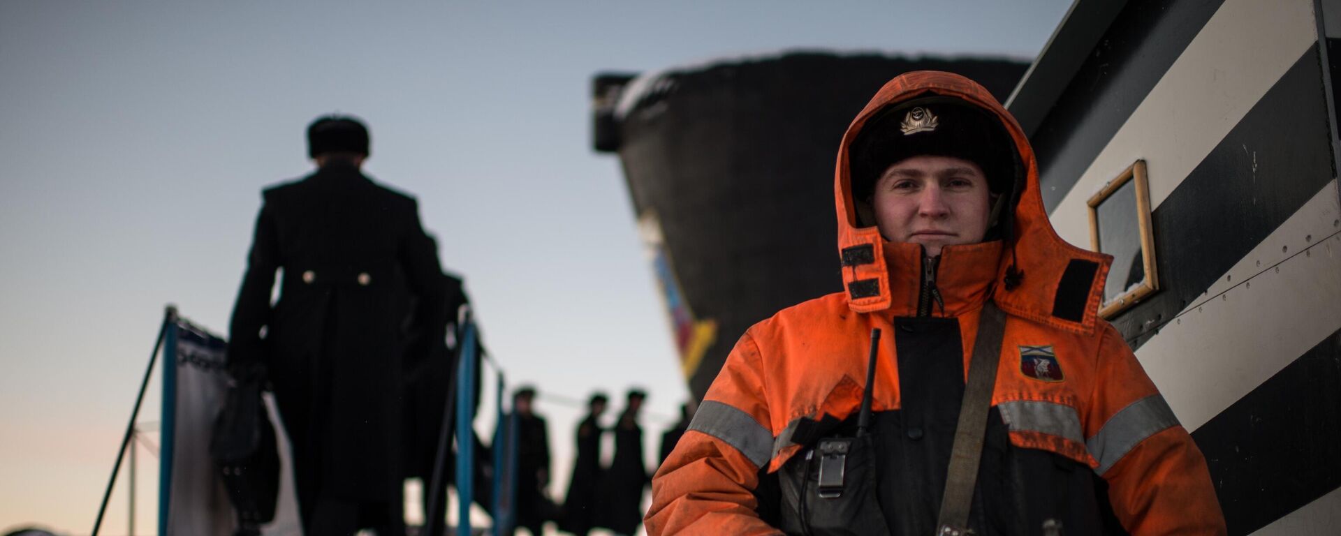 Một quân nhân thành viên thủy thủ đoàn của tàu ngầm hạt nhân Yuri Dolgoruky thuộc Hạm đội phương Bắc của Hải quân Nga, neo đậu tại cầu tàu ở Gadzhiyevo, vùng Murmansk - Sputnik Việt Nam, 1920, 19.03.2025