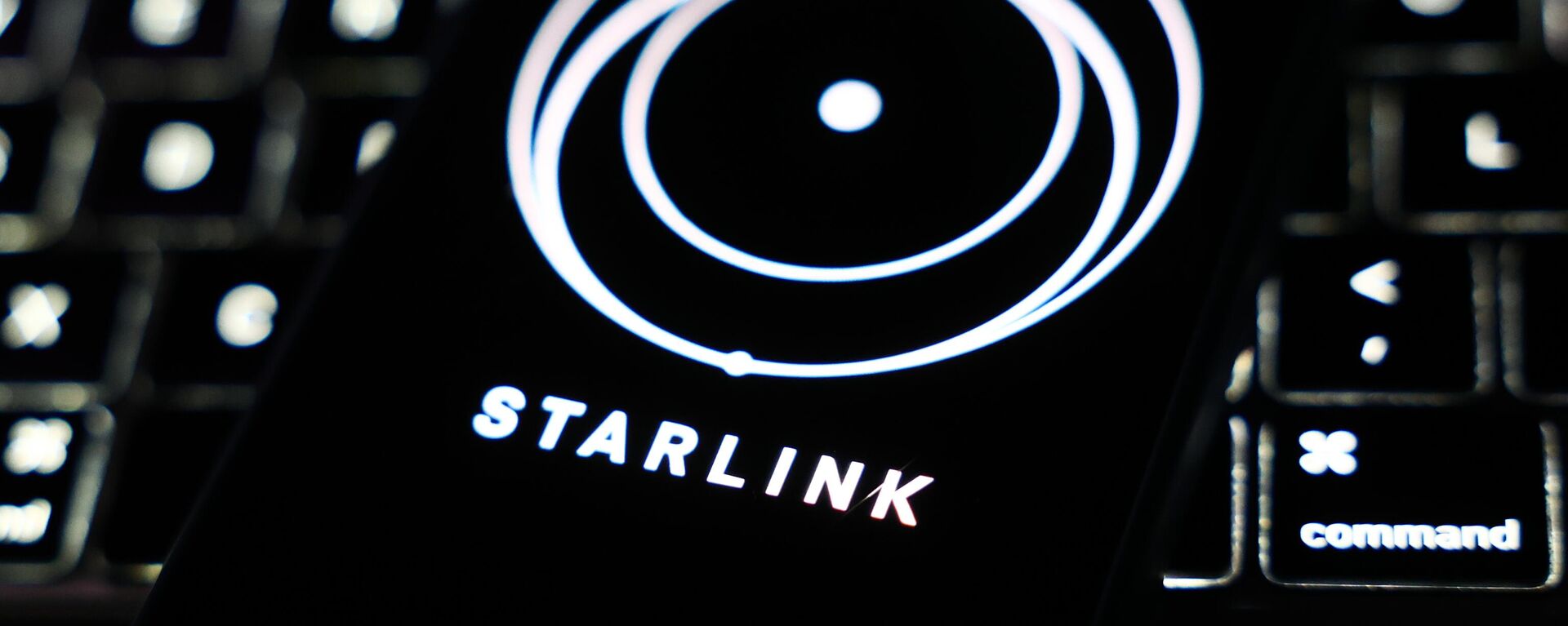 Đây là một chiếc điện thoại thông minh có ứng dụng Starlink trên nền bàn phím máy tính - Sputnik Việt Nam, 1920, 12.04.2025