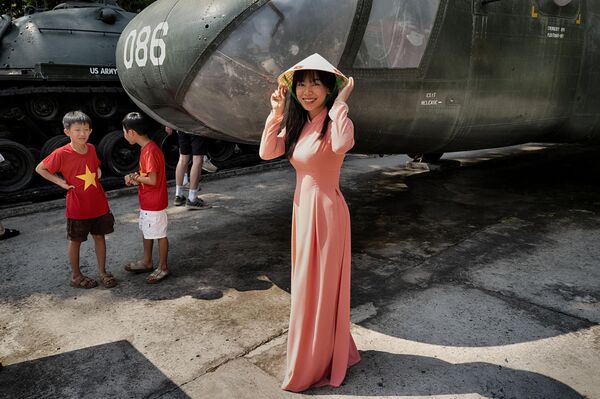 Người dân Việt Nam bên chiếc trực thăng chiến lợi phẩm của Quân đội Hoa Kỳ trong lễ kỷ niệm 50 năm ngày kết thúc Chiến tranh Việt Nam tại Thành phố Hồ Chí Minh - Sputnik Việt Nam