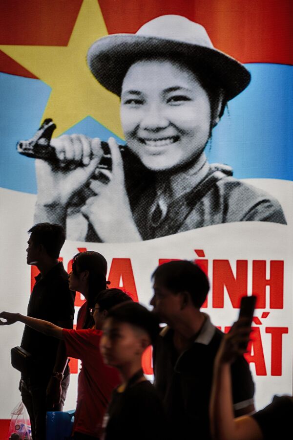 Những người tham gia hoạt động trước bảng quảng cáo điện tử kỷ niệm 50 năm ngày kết thúc chiến tranh tại Thành phố Hồ Chí Minh, Việt Nam - Sputnik Việt Nam