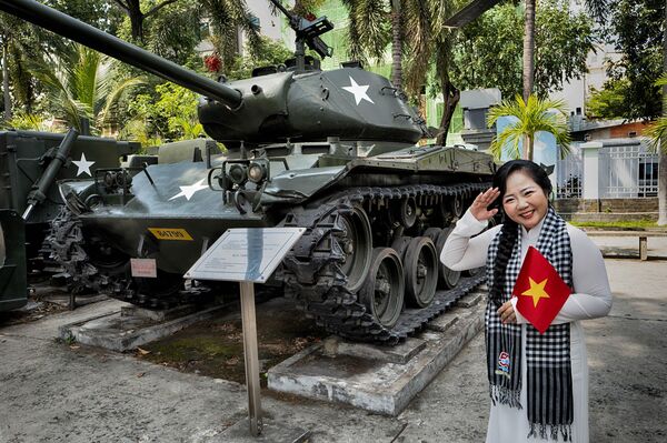 Khách tham quan chụp ảnh cùng xe tăng chiến lợi phẩm của Quân đội Hoa Kỳ trong lễ kỷ niệm 50 năm ngày kết thúc Chiến tranh Việt Nam tại Thành phố Hồ Chí Minh - Sputnik Việt Nam