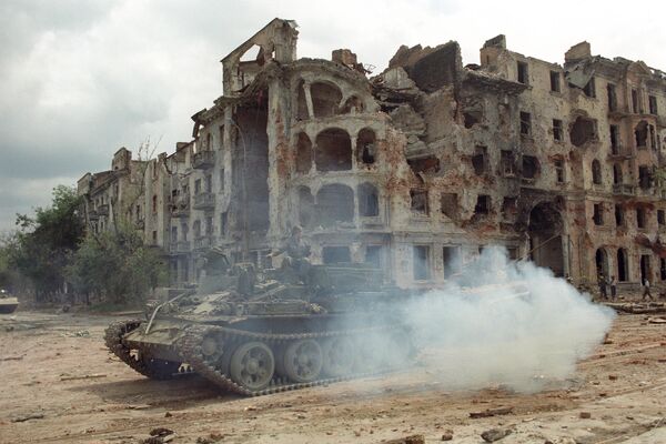 Chiến sự tại Grozny, tháng 8/1996. Xe bọc thép của lực lượng nội vụ Nga giữa những ngôi nhà đổ nát ở trung tâm thành phố. - Sputnik Việt Nam