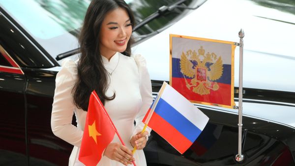 Một cô gái gần xe hộ tống Tổng thống Liên bang Nga Vladimir Putin tại Phủ Thủ tướng Chính phủ Cộng hòa xã hội chủ nghĩa Việt Nam tại Hà Nội. - Sputnik Việt Nam