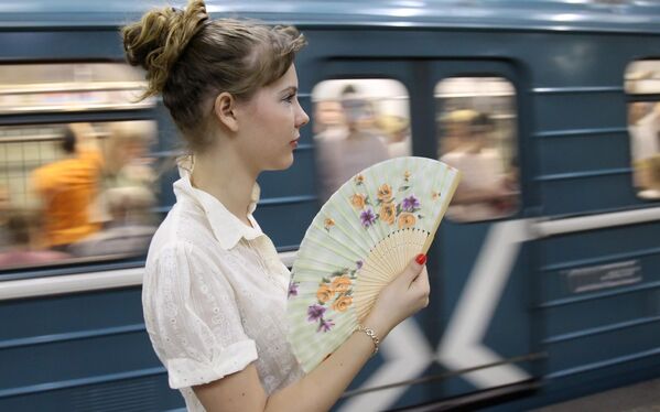 Cô gái dùng quạt giấy làm mát trên sân ga, năm 2010 - Sputnik Việt Nam