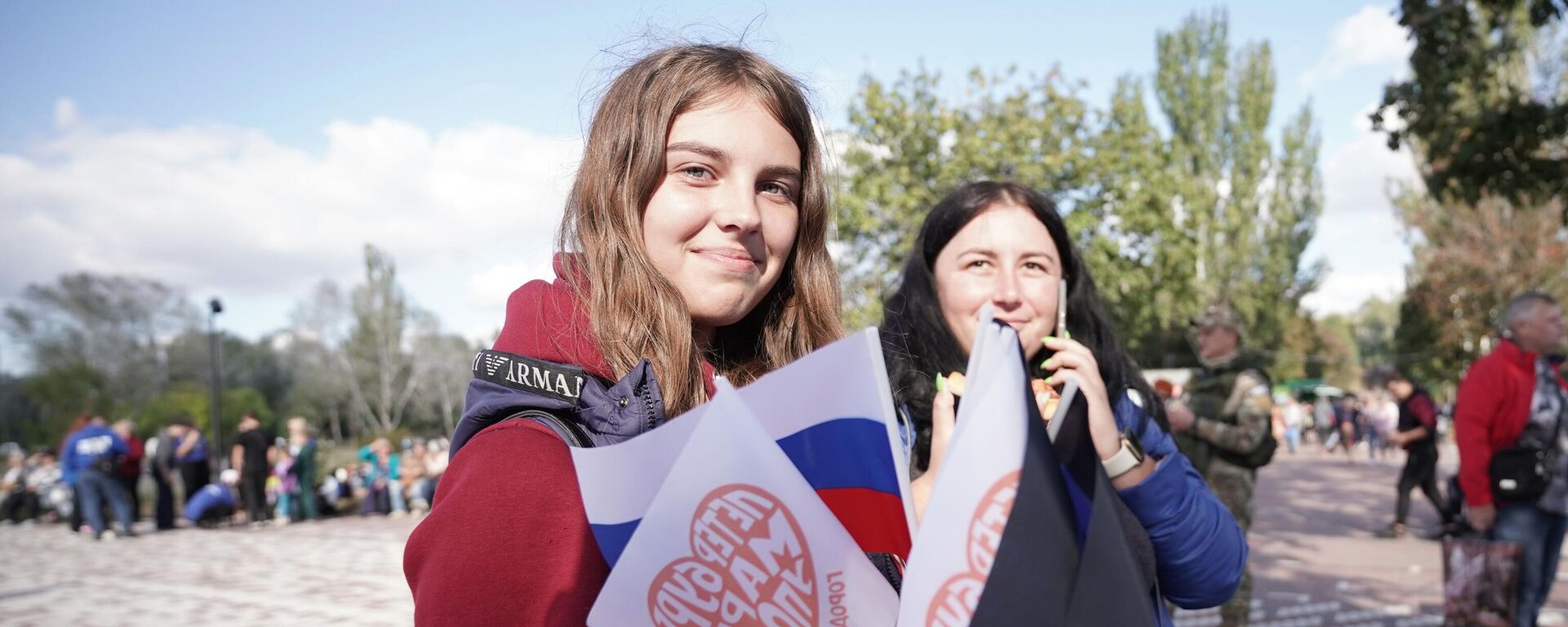 Những cô gái trẻ trong lễ hội kỷ niệm ngày thành lập thành phố tại công viên Gurov vừa được sửa chữa xong ở Mariupol - Sputnik Việt Nam, 1920, 20.05.2025