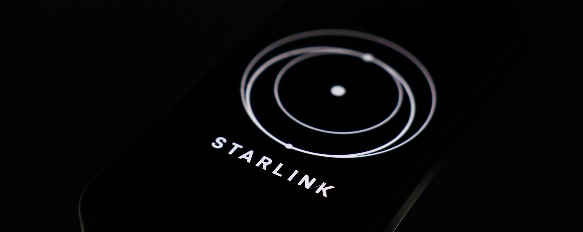 Смартфон со включенным приложением Starlink на фоне логотипа SpaceX - Sputnik Việt Nam, 1920, 21.05.2025