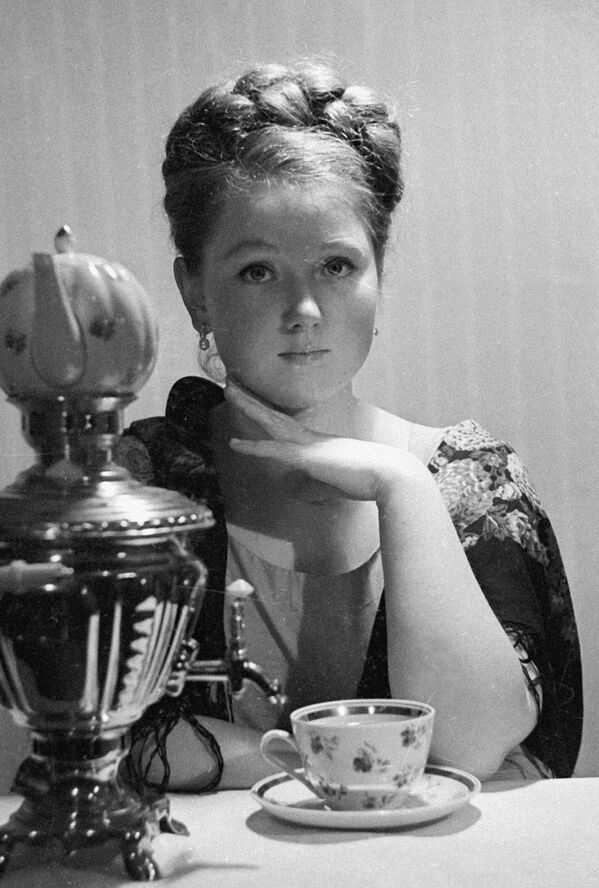 Một cô gái bên chiếc ấm samovar đang chuẩn bị uống trà Một cô gái bên chiếc ấm samovar đang chuẩn bị uống trà - Sputnik Việt Nam