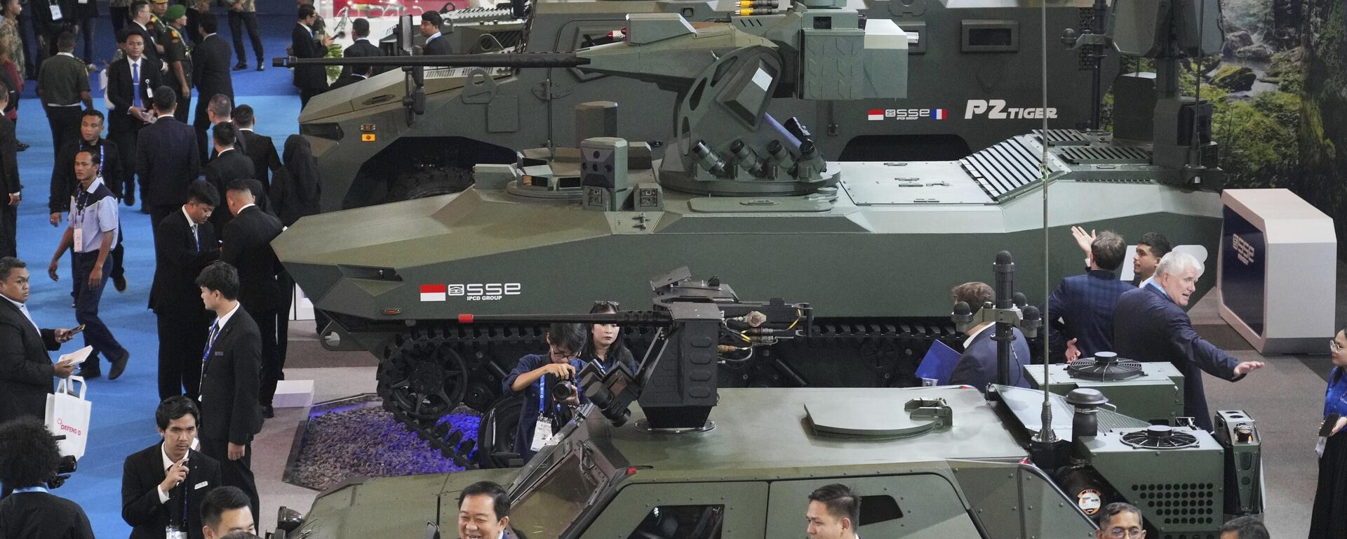 Khách tham quan đi ngang qua các xe bọc thép được trưng bày tại triển lãm công nghệ quốc phòng và vũ khí Indo Defence 2025 - Sputnik Việt Nam, 1920, 13.06.2025