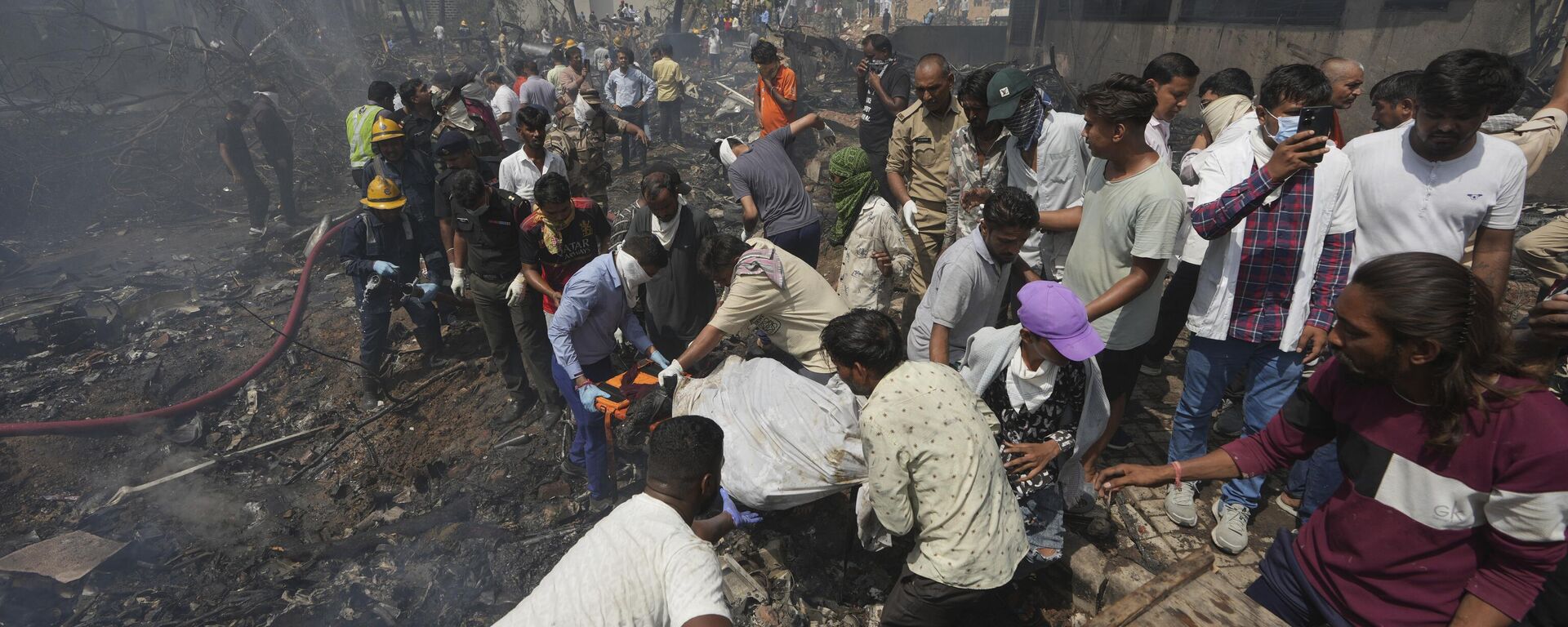 Lực lượng cứu hộ đang mang thi thể nạn nhân vụ tai nạn máy bay ở thành phố Ahmedabad, bang Gujarat, tây bắc Ấn Độ - Sputnik Việt Nam, 1920, 12.06.2025