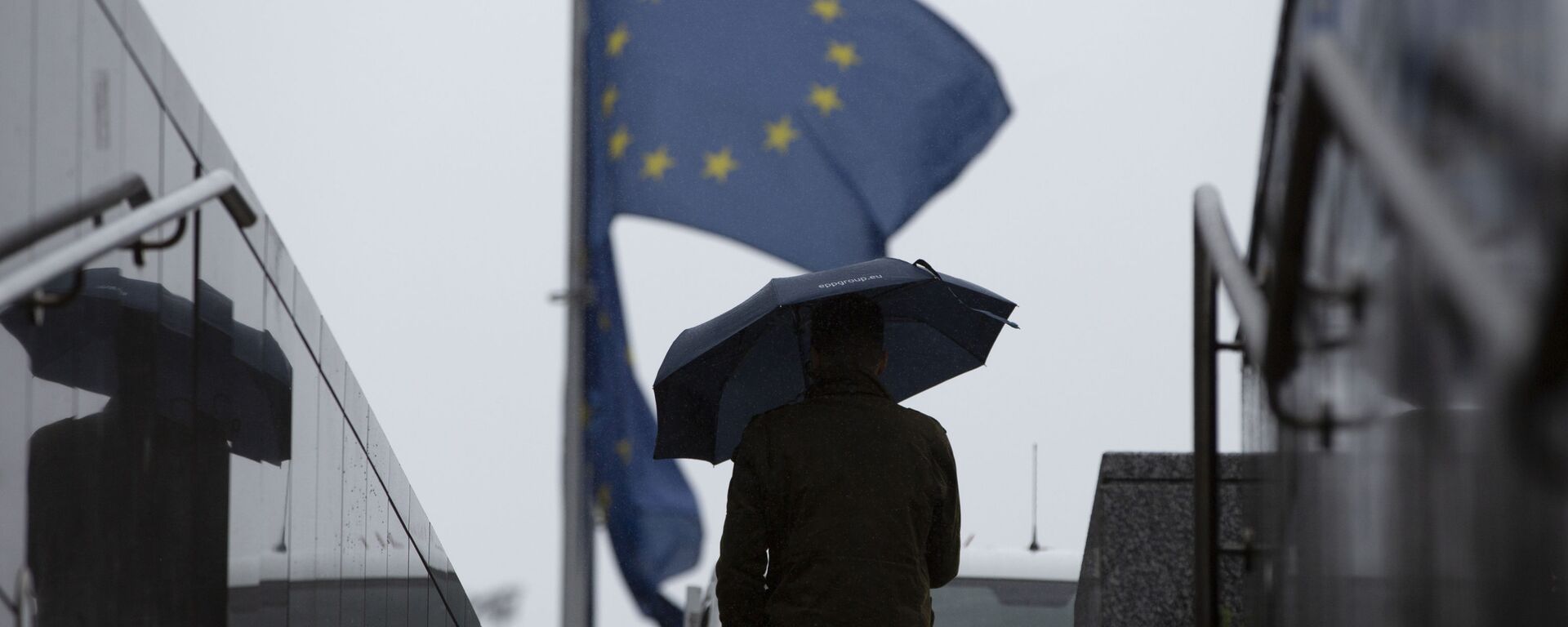 Một người đàn ông đi ngang qua trụ sở EU ở Brussels - Sputnik Việt Nam, 1920, 26.10.2025