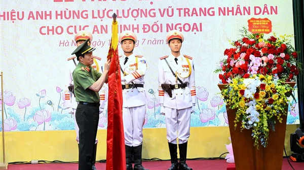 Bộ trưởng Lương Tam Quang trân trọng gắn danh hiệu Anh hùng lực lượng vũ trang nhân dân lên lá cờ truyền thống của Cục An ninh đối ngoại - Sputnik Việt Nam