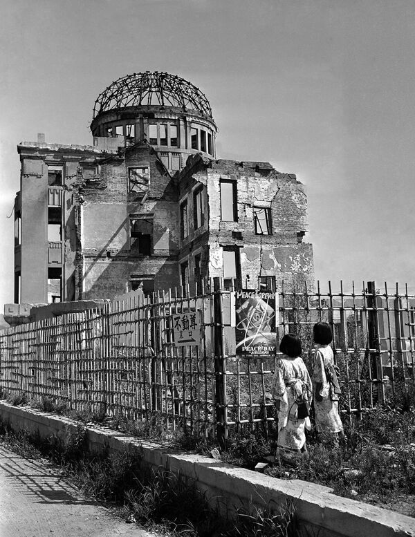 Những đứa trẻ nhìn vào tấm áp phích gần địa điểm quả bom rơi xuống tại Hiroshima - Sputnik Việt Nam