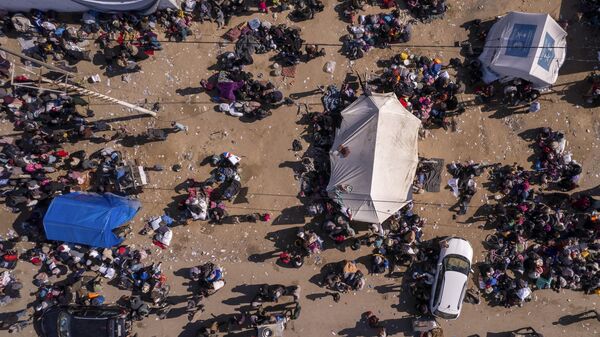 Người dân Palestine tại một trạm kiểm soát trên phố Al-Rashid đang chờ trở về nhà ở phía bắc Dải Gaza - Sputnik Việt Nam