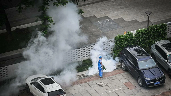 Nhân viên y tế phun thuốc diệt muỗi tại sân để xe của một tòa nhà ở Trung Quốc - Sputnik Việt Nam