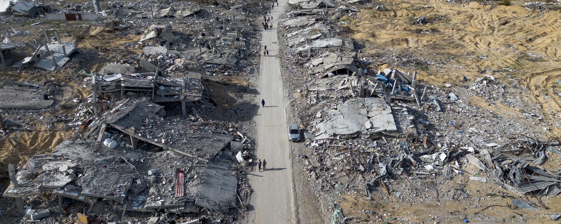 Người dân Palestine đi qua đống đổ nát do các cuộc không kích và tấn công trên bộ của Israel để lại ở Rafah - Sputnik Việt Nam, 1920, 19.10.2025