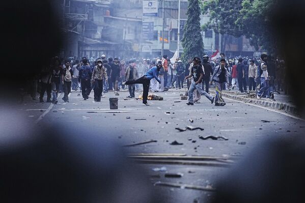 Người biểu tình ném đá về phía cảnh sát trong cuộc biểu tình phản đối tăng phụ cấp và đặc quyền cho các thành viên quốc hội tại Jakarta, Indonesia - Sputnik Việt Nam