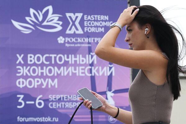 Cô gái đứng trước băng-rôn Diễn đàn Kinh tế Phương Đông trên đường Svetlanskaya ở Vladivostok - Sputnik Việt Nam