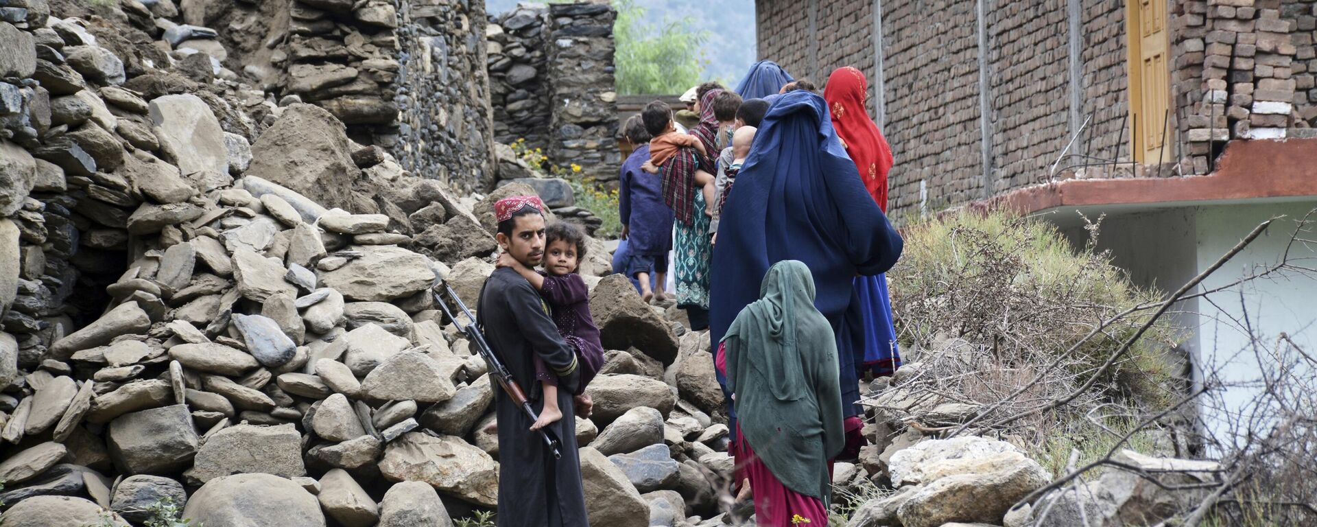 Người dân địa phương đi ngang qua một ngôi nhà bị phá hủy bởi trận động đất ở Mazar Dara, tỉnh Kunar, Afghanistan. - Sputnik Việt Nam, 1920, 02.09.2025