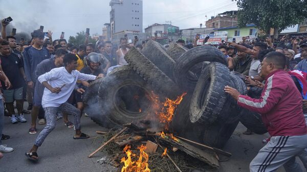 Những người biểu tình phản đối lệnh cấm mạng xã hội và tham nhũng đốt lốp xe trong giờ giới nghiêm ở Kathmandu, Nepal - Sputnik Việt Nam