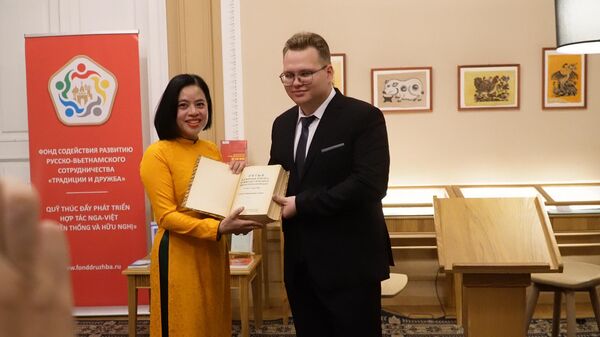 Pavel Bolshakov đưa cuốn sách cho Đỗ Thị Thu Hằng  - Sputnik Việt Nam