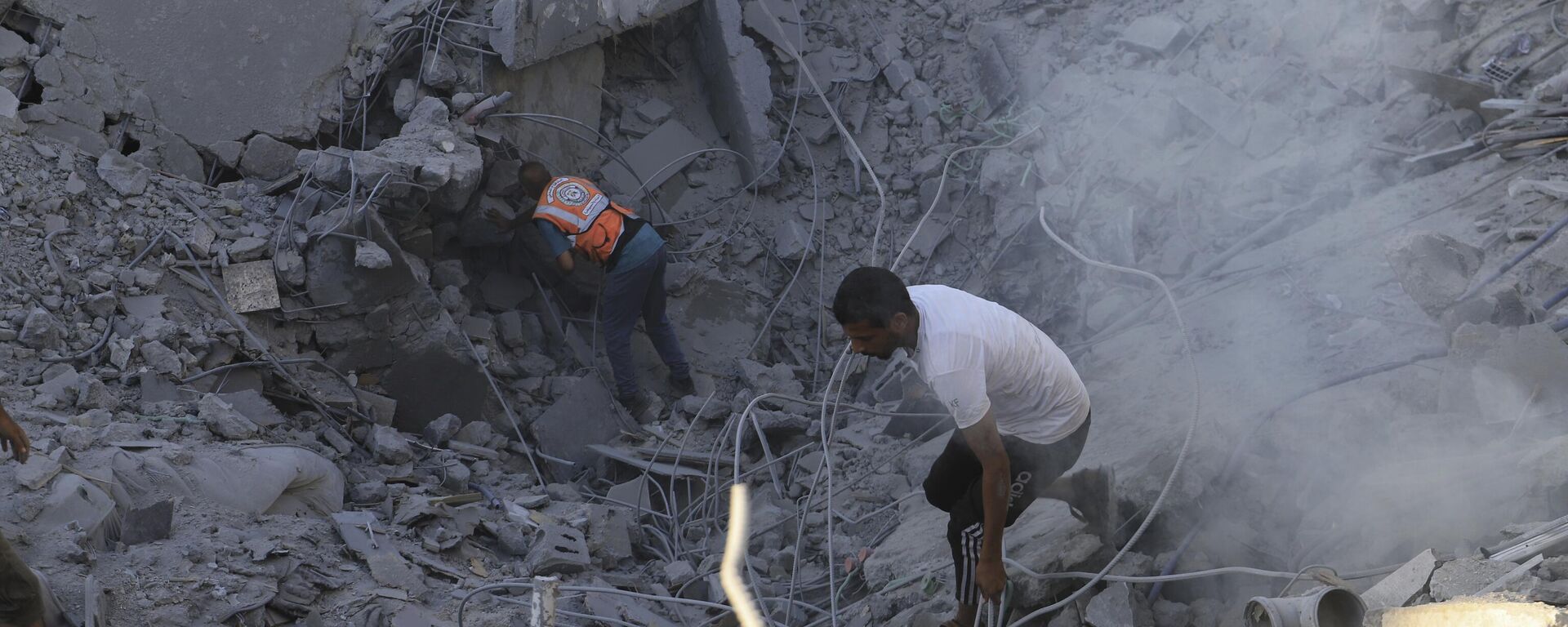 Người dân Palestine tìm kiếm thi thể và người sống sót trong đống đổ nát của một tòa nhà dân cư bị phá hủy trong cuộc không kích của Israel tại Khan Younis, Dải Gaza, Thứ Tư, ngày 3 tháng 7 năm 2024 - Sputnik Việt Nam, 1920, 14.09.2025