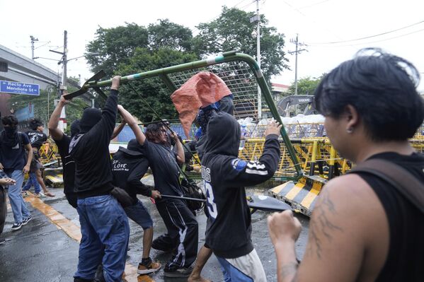 Người biểu tình mang theo rào chắn thép trong cuộc đụng độ với cảnh sát khi cố gắng đột nhập địa bàn Dinh Tổng thống Malacañang ở Manila, Philippines - Sputnik Việt Nam