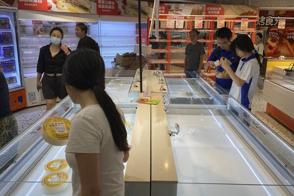 Khách hàng đi ngang qua các kệ hàng trống trơn trong siêu thị trước khi bão “Ragasa” đổ bộ vào Thâm Quyến, tỉnh Quảng Đông, miền nam Trung Quốc - Sputnik Việt Nam