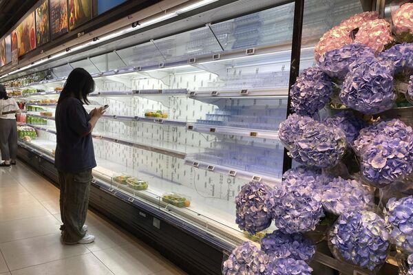 Khách hàng đứng cạnh các kệ hàng gần như trống rỗng trong siêu thị trước khi bão “Ragasa” đổ bộ vào Thâm Quyến, tỉnh Quảng Đông, miền nam Trung Quốc - Sputnik Việt Nam