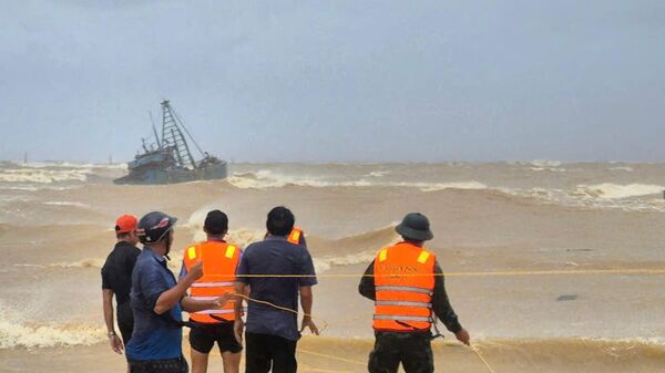 Mọi người giải cứu các ngư dân từ tàu đánh cá mắc cạn do bão Bualoi ở Quảng Trị, Việt Nam - Sputnik Việt Nam