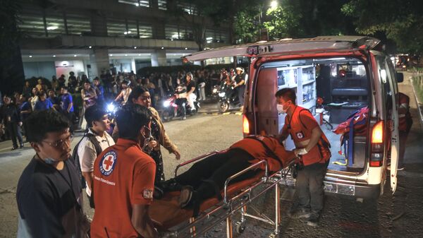 Các nhân viên y tế đưa nạn nhân lên xe cứu thương sau trận động đất mạnh tại Thành phố Cebu, Philippines - Sputnik Việt Nam