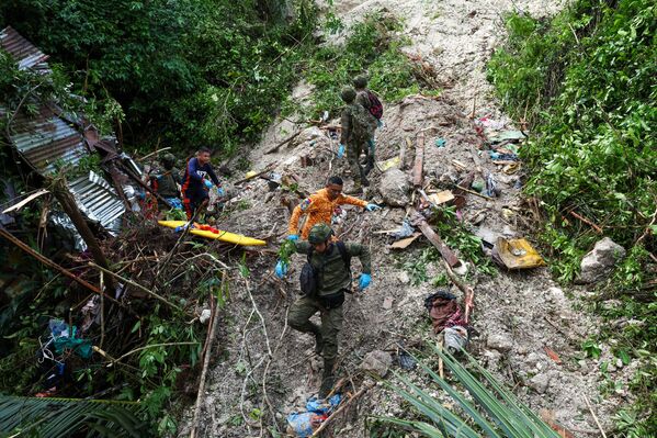Lực lượng cứu hộ và binh lính tiếp tục tìm kiếm người có thể bị mắc kẹt bên trong ngôi nhà bị phá hủy bởi lở đất sau trận động đất tại Thành phố Cebu, Philippines - Sputnik Việt Nam