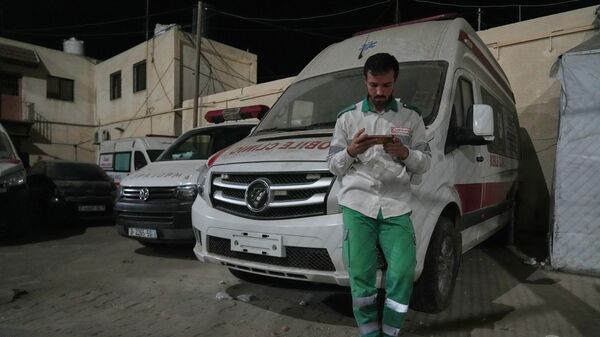 Nhân viên y tế Palestine Said Awad  tại Bệnh viện Al-Aqsa ở Deir el-Balah theo dõi tin tức trên điện thoại sau thông báo Israel và Hamas đã đồng ý về giai đoạn đầu tiên của kế hoạch hòa bình nhằm chấm dứt giao tranh. Ngày 9 tháng 10 năm 2025 - Sputnik Việt Nam