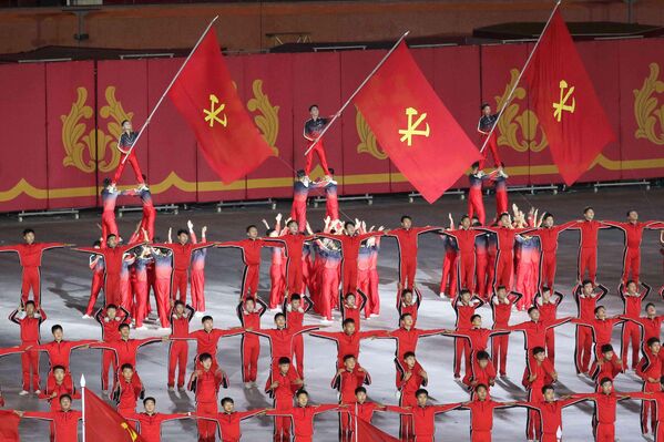 Các vận động viên thể dục dụng cụ vẫy cờ đảng trong buổi lễ kỷ niệm 80 năm thành lập Đảng Lao động đang lãnh đạo đất nước - Sputnik Việt Nam