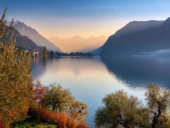 Cảnh quan hồ nước thanh bình và núi non lúc hoàng hôn với những tán lá mùa thu, Lugano, Thụy Sĩ - Sputnik Việt Nam