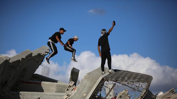 Các vận động viên trẻ người Palestine trình diễn kỹ thuật parkour giữa đống đổ nát của những tòa nhà bị phá hủy ở khu vực Al-Mugraqa sau lệnh ngừng bắn ở Thành phố Gaza. - Sputnik Việt Nam