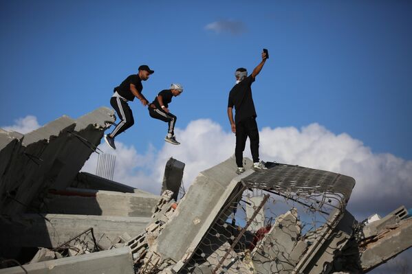 Các vận động viên trẻ người Palestine trình diễn kỹ thuật parkour giữa đống đổ nát của những tòa nhà bị phá hủy ở khu vực Al-Mugraqa sau lệnh ngừng bắn ở Thành phố Gaza. - Sputnik Việt Nam