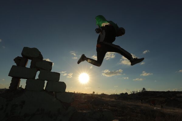Các vận động viên trẻ người Palestine trình diễn kỹ thuật parkour giữa đống đổ nát của những tòa nhà bị phá hủy ở khu vực Al-Mugraqa sau lệnh ngừng bắn ở Thành phố Gaza. - Sputnik Việt Nam