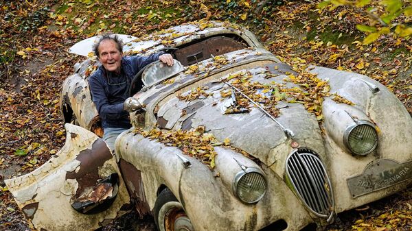 Nhà sưu tập Michael Frohlich đứng cạnh chiếc Jaguar XK120 cổ trong công viên tư nhân của ông tại Mettmann, Đức - Sputnik Việt Nam