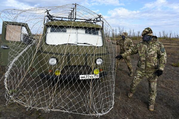 Các binh sĩ đang chuẩn bị một chiếc xe được trang bị lưới chắn bảo vệ chống UAV cho đợt thử nghiệm trên thao trường ở tỉnh Rostov - Sputnik Việt Nam