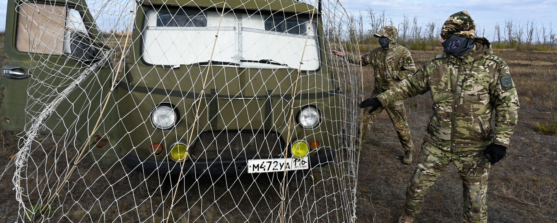 Các binh sĩ đang chuẩn bị một chiếc xe được trang bị lưới chắn bảo vệ chống UAV cho đợt thử nghiệm trên thao trường ở tỉnh Rostov - Sputnik Việt Nam, 1920, 01.11.2025