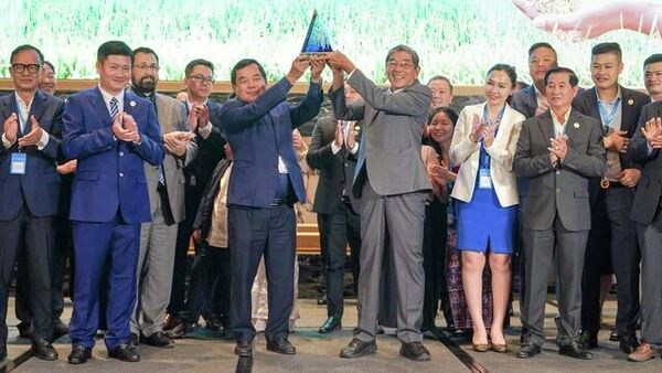 Ông Đỗ Hà Nam (bên trái) và ông Hồ Quang Cua (bên phải ) nâng biểu trưng Gạo ngon nhất thế giới trong sự tán thưởng của cộng đồng - Sputnik Việt Nam