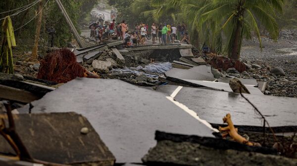 Người dân kiểm tra con đường quốc lộ bị phá hủy bởi siêu bão Fung-wong tại Dipaculao, tỉnh Aurora, Philippines - Sputnik Việt Nam