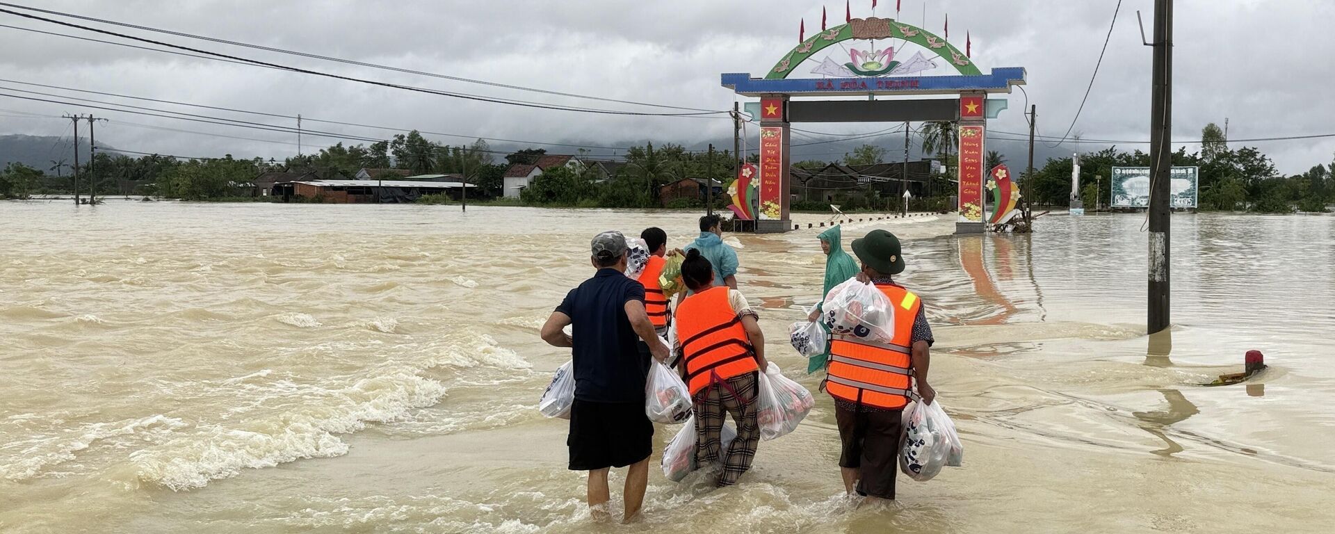 Người dân băng qua dòng lũ đem lương thực về nhà tiếp tế cho gia đình - Sputnik Việt Nam, 1920, 24.11.2025